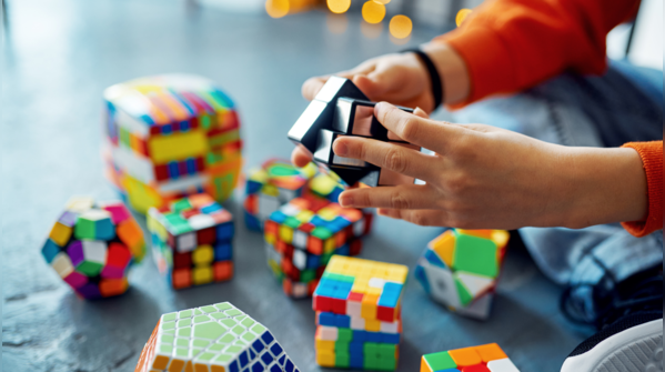 Hands playing a brain-teasing puzzle game.