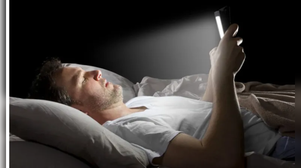 Electronics emitting harmful blue light near the bed.