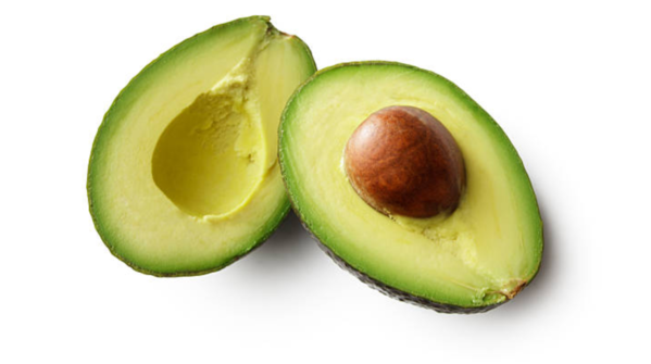 Avocado on a plate next to salad